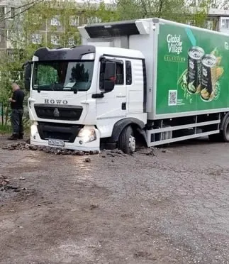 Грузовой автомобиль застрял передними колёсами из‑за просевшего грунта между домами на ул. Коммунальная. Дорога относится к муниципалитету, на место направили погрузчик.
