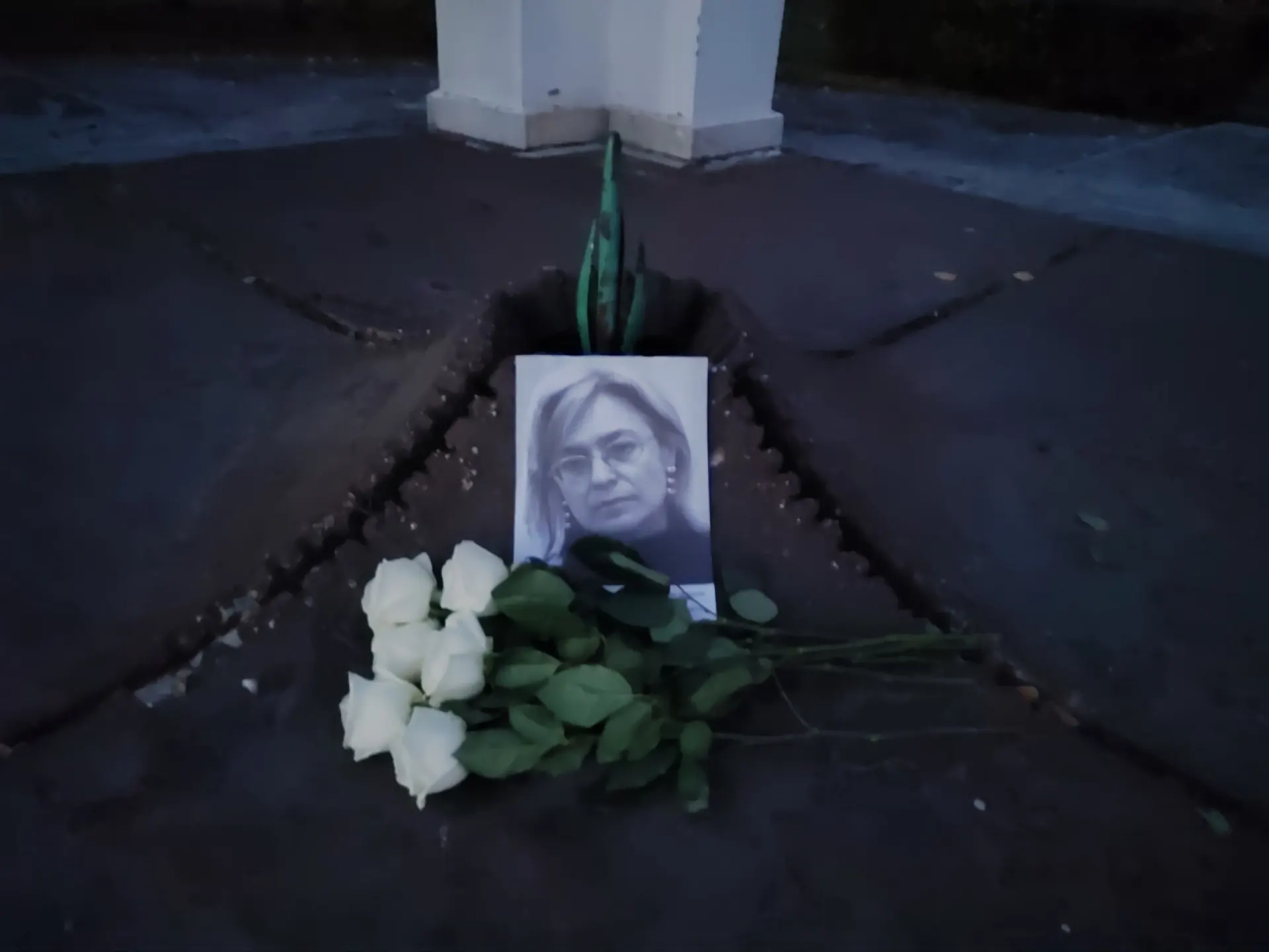 У мемориала появились цветы и портрет Анны Политковской; журналистка погибла в 2006 году в лифте своего дома; преступник по делу так и не найден.